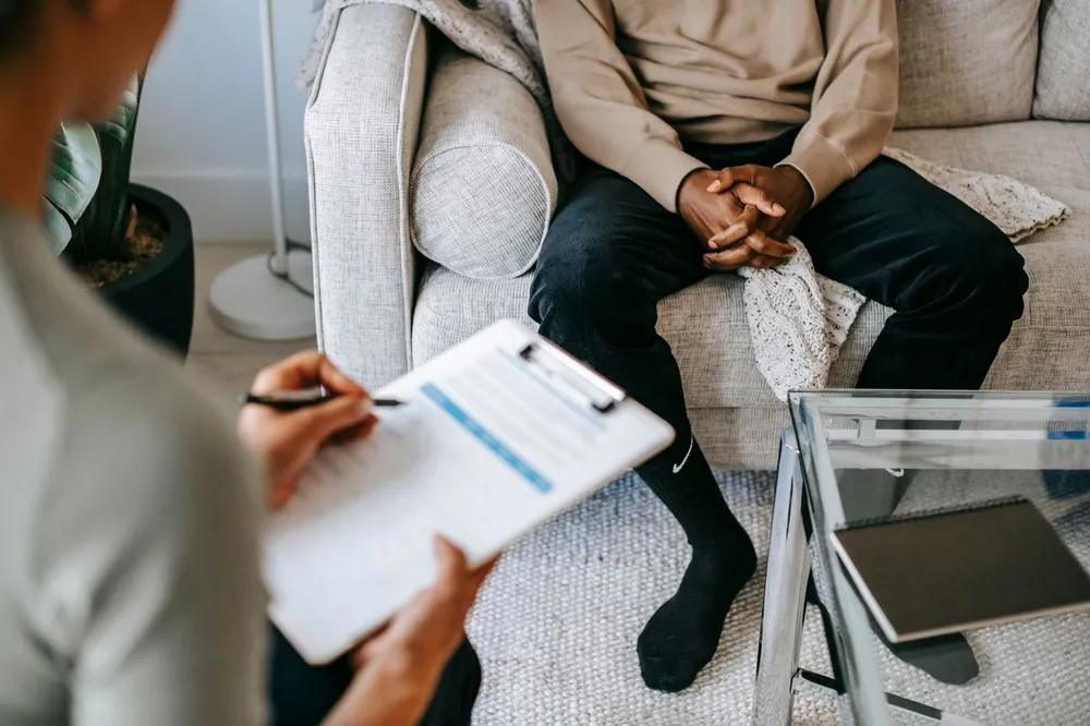 Profissional fazendo anotações em uma sessão de psicoterapia